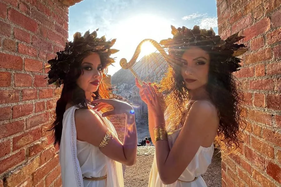 Due ragazze con il sole alle spalle durante una serata e festa greca